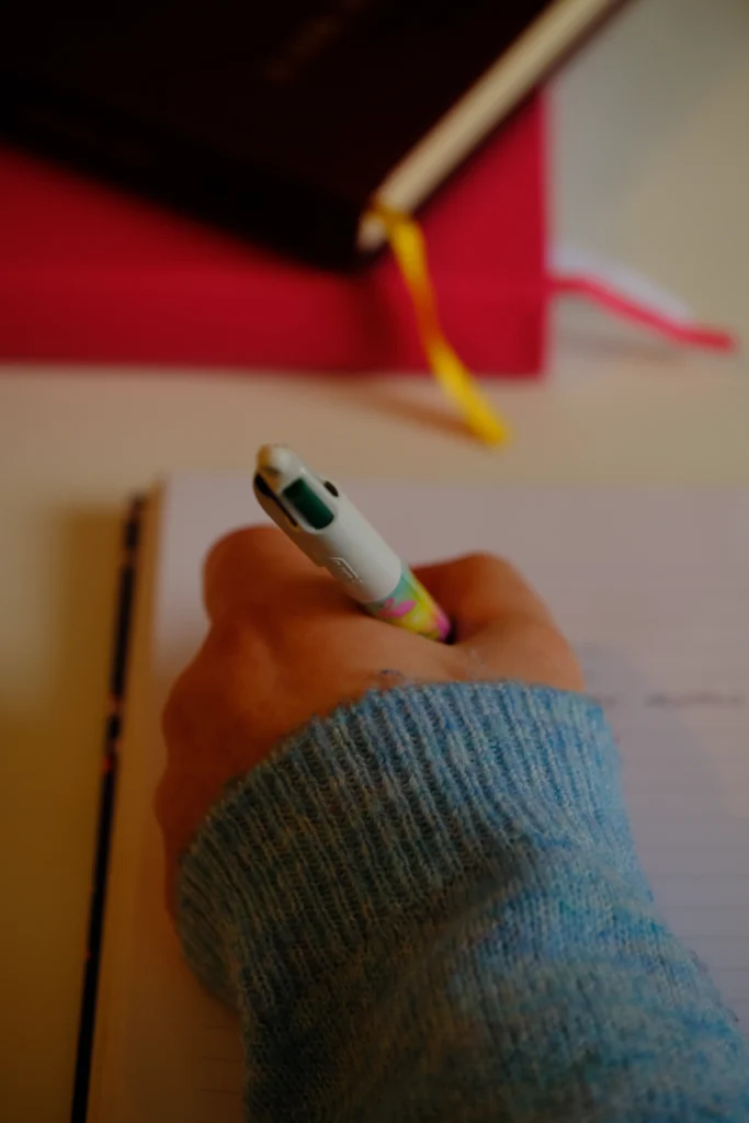 Handwriting notes in a journal with a colourful pen, symbolising creative copywriting and brand storytelling